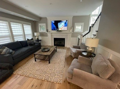 A beautifully arranged living room with a dark sofa, coffee table, and fireplace after a completed Tampa senior move.