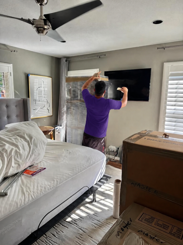 South Tampa 8 Mover wrapping bedroom furniture and prepping a wall-mounted TV in South Tampa, FL