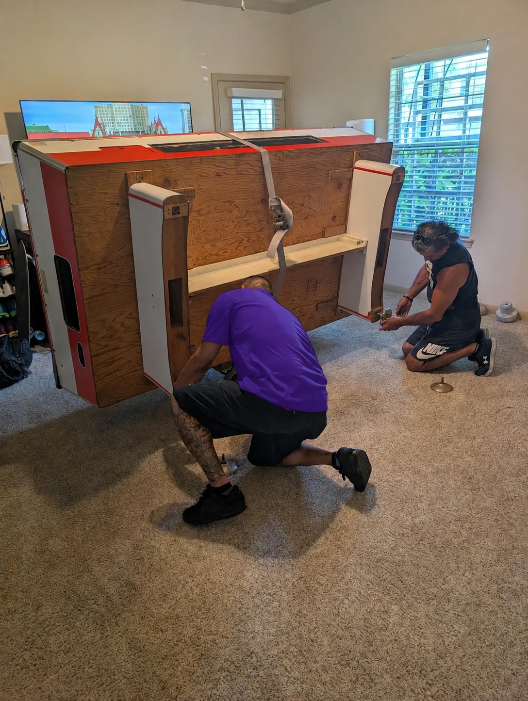 Wesley Chapel Movers 10 Movers reattaching the legs on a game table after a move in Wesley Chapel, FL