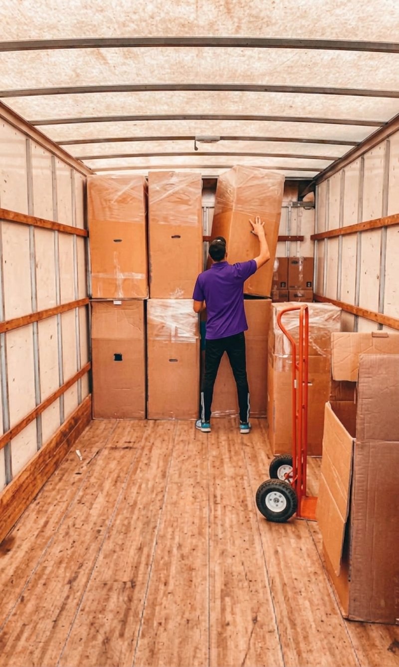 Mover stacking wardrobe boxes inside a moving truck in Tampa, FL