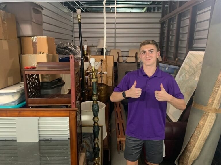 Mover giving two thumbs up in a packed storage unit in Brandon, FL