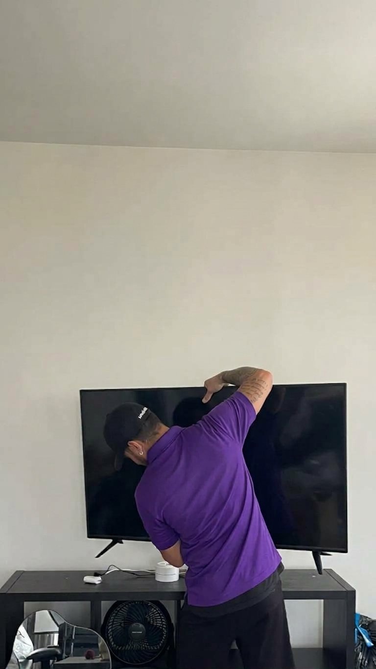 Wesley Chapel Movers 4 Mover taking a flat-screen TV down for a move in Wesley Chapel, FL